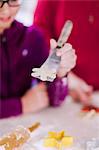 Girl and grandmother with star cookie dough on spatula