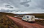 Campervan parked on dirt track by river, Yanaoca, Cusco, Peru