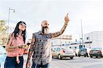 Mature hipster couple hailing a cab, Valencia, Spain