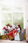 Girl photographing boy and music teacher on window seat