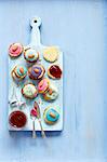 Biscuits with strawberry jam and icing (poppy seeds and almonds as decoration)