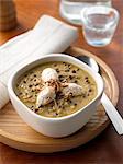 A bowl of lentil soup with chicken breast quenelles