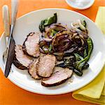 Sliced pork tenderloin with onions and greens