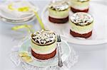 Matcha cream tarts with dark chocolate bases, almond and tonka bean cream, white chocolate and matcha cream, matcha jelly, and grated white chocolate (vegan)