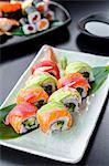 Japanese platter of rainbow rolls maki, inside out seaweed and rice roll filled with cucumber, mayonnaise, avocado, crub stick topped with fresh salmon, tuna, avocado and prawn