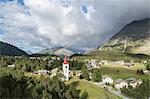 Rainbow over Chiesa Bianca and the village of Maloja, Bregaglia Valley, Engadine, Canton of Graubunden (Grisons), Switzerland, Europe