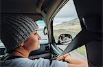 Young woman sitting in car, looking at view out of car window, Silverthorne, Colorado, USA