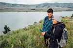 Couple standing beside Dillon Reservoir, using digital tablet, Silverthorne, Colorado, USA