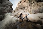 Children playing on rocks in river, Lake Arrowhead, California, USA