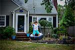 Boy playing on tyre swing in garden