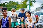 Portrait of teenage boy with woman and her children on street