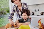 Mother and son preparing food in kitchen