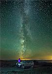 Person sitting on car, looking at view of milky way, rear view, Nickel Plate Provincial Park, Penticton, British Columbia, Canada