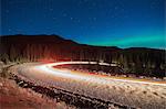 Northern lights, and long exposure light trails from vehicles on road, Nickel Plate Provincial Park, Penticton, British Columbia, Canada