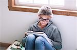 Girl sitting on floor writing up homework