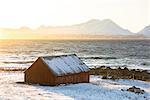 The winter sun hits a typical house, Nordmannvik, Kafjord, Lyngen Alps, Tromso, Norway, Europe