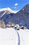 A trail in the snow leads to the traditional huts of Blatten. Zermatt, Canton of Valais / Wallis, Switzerland.