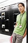 Portrait of an Asian American computer technician in a large computer server room