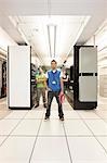 Portrait of three multi-ethnic technicians who work in a large computer server room.