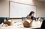 Caucasian woman working through lunch at a conference room table.