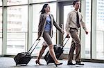 Businesspeople walking through a covered walkway on the way to catch a plane.