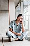 Asian woman doctor in scrubs in a hospital hallway.