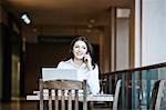 Caucasians business woman on the phone in a coffee shop.