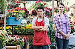 Caucasian man and woman employees of a garden centre nursery.