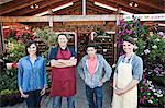 Plant nursery store owners and employees standing in a row in front the store.