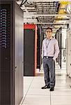 Caucasian man technician working with computer servers in a computer server farm.