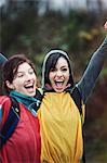 Two women cheering at an informal outdoor sporting event.