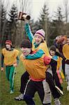 Team members celebrating a victory and a trophy in an outdoor sporting event in the winter.