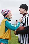 Caucasian woman team member arguing with a referee while playing non-contact flag football.