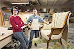 A young Caucasian couple working on a chair as a team of upholsterers.