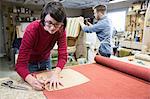 A young Caucasian couple working on a chair as a team of upholsterers.