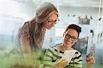 Smiling creative businesswomen with prototype using digital tablet