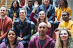 Woman participating, raising hand in conference audience