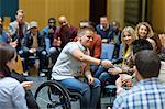 Female speaker in wheelchair giving microphone to audience