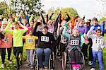 Portrait enthusiastic crowd cheering at charity run in park