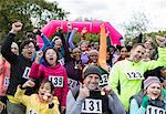 Portrait cheering crowd with medals finishing charity run