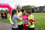 Happy family hugging at charity run in park