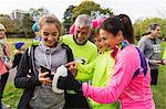 Family runners with smart phone at charity run in park