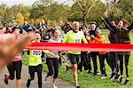 Enthusiastic family running, nearing charity run finish line in park