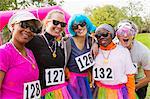 Portrait smiling, playful runner friends at charity run in park