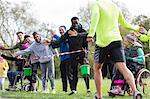 Spectators high-fiving runners at charity run in park