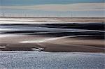 Wind turbines in distance beyond bay, Morecambe Bay, UK