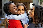 Affectionate mother and daughters hugging