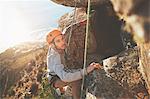 Focused male rock climber climbing rock