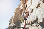 Female rock climber scaling rock
