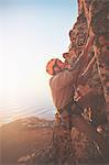 Male rock climber scaling rock